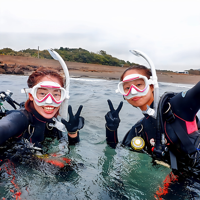 沖ノ島で体験ダイビングに参加する初心者の女性。インストラクターがすぐそばでサポートし、初めてでも安心して海に慣れている様子。