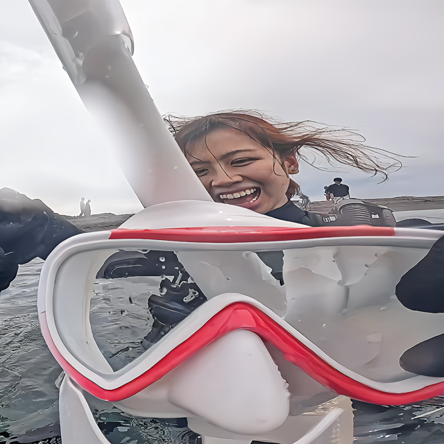 初めて一人でダイビングに参加した女性が、沖ノ島の海で少し緊張しながらも安心した表情を見せている瞬間。ソロ参加でも無理せず楽しめる雰囲気が伝わる一枚。