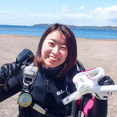 一人でダイビングに参加した女性が、沖ノ島で器材を準備している様子。インストラクターと落ち着いて話しながら、自分のペースで海に向かう前の時間を過ごしている。